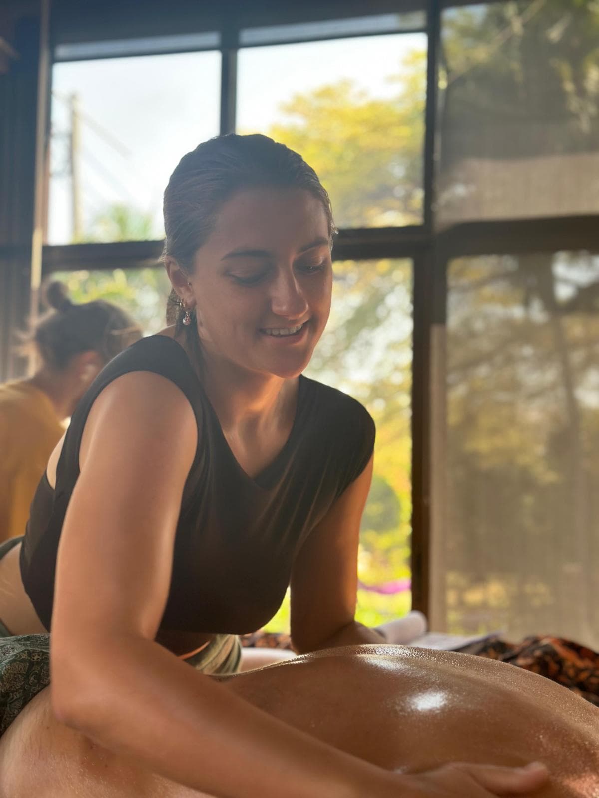 Skyla giving a massage in warm golden light